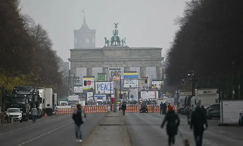  People walk towards Berlin's Brandenburg Gate ahead of celebrations for the 35th anniversary of the Berlin Wall's fall.