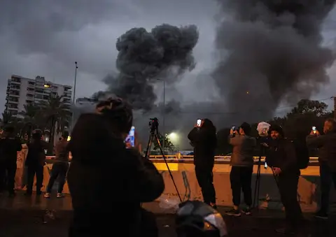 Media and the public capture the moment of an Israeli strike on a building in Beirut’s Chiyah district, November 25, 2024.