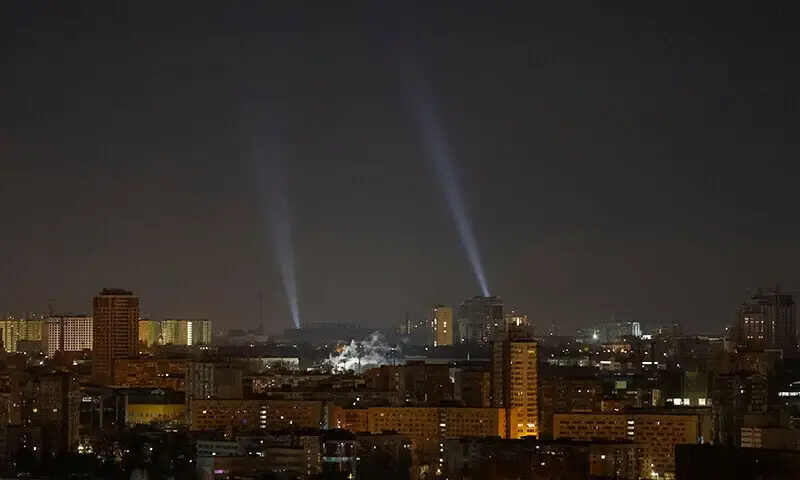 Ukrainian personnel use searchlights in Kyiv during a Russian drone strike amid the ongoing Ukraine conflict on November 20.