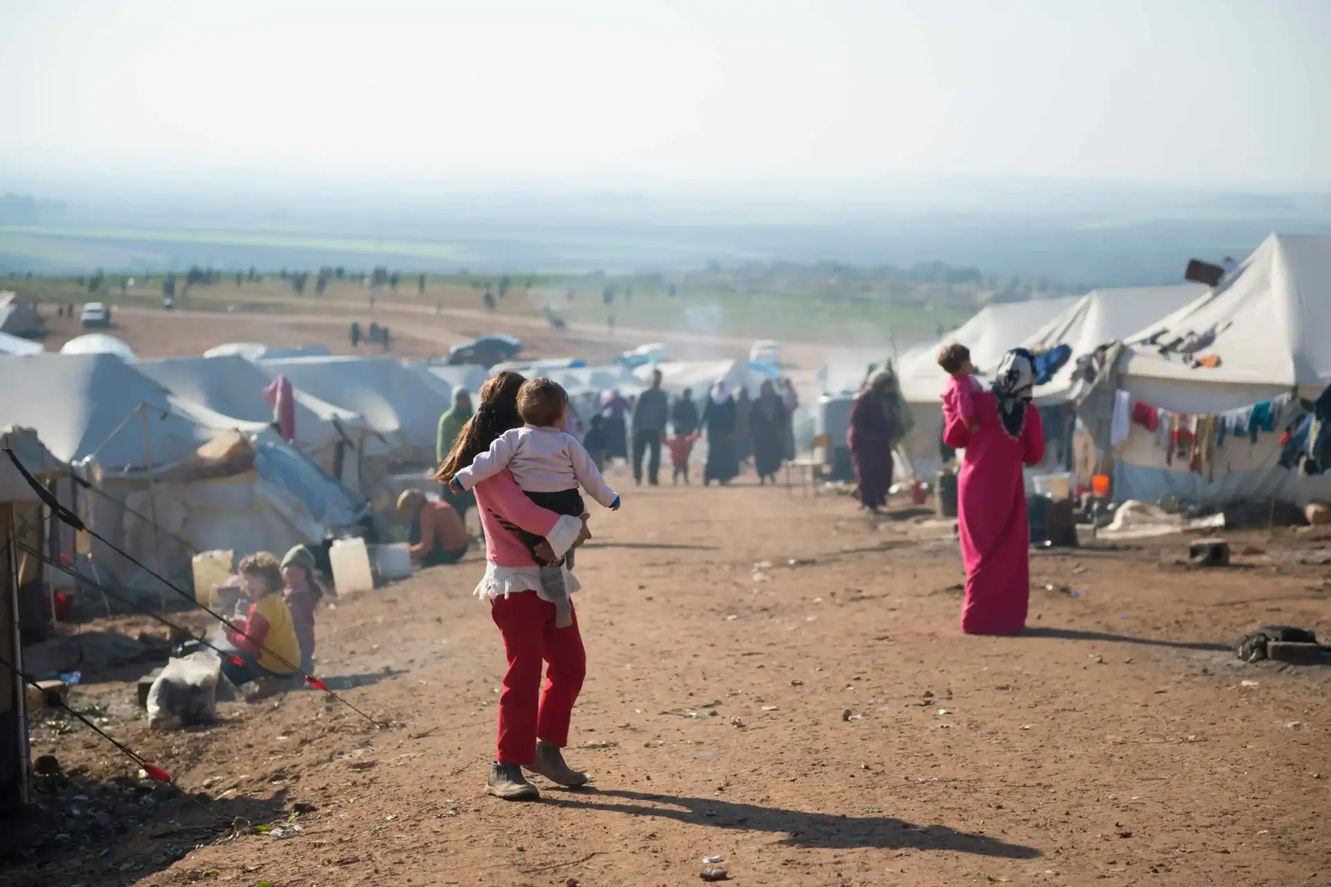 Displaced people near tents in Tabqa, Syria, as they flee the Aleppo countryside, December 4, 2024.