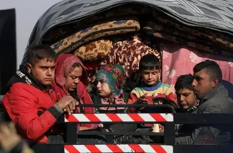  Displaced people from Aleppo countryside sit on a truck in Tabqa, Syria, showcasing the humanitarian impact of the Syrian civil war.