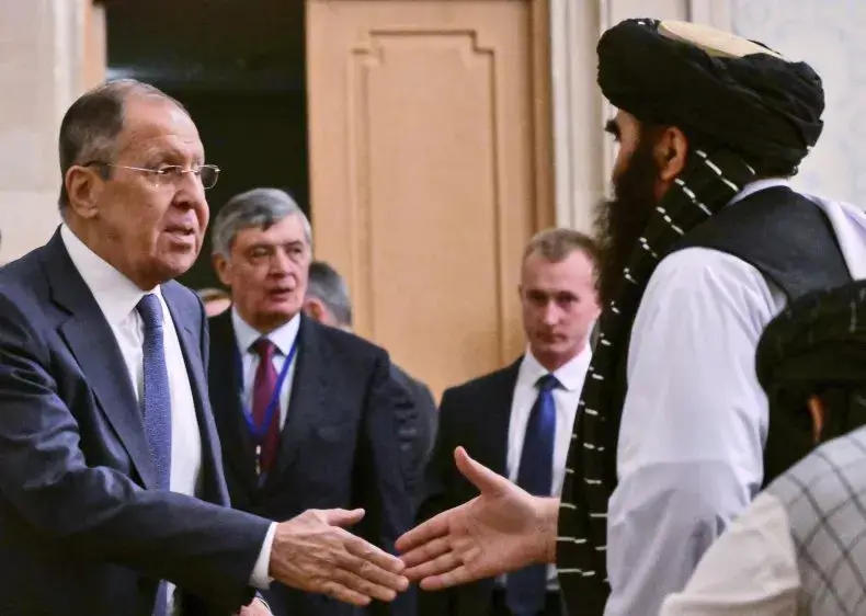 Russian FM Sergey Lavrov shakes hands with Taliban's Acting FM Amir Khan Muttaqi during an Oct. 4 meeting.