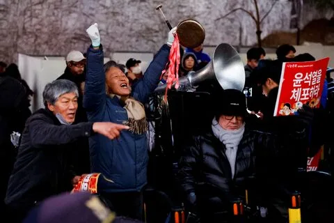 Protesters rally against South Korean President Yoon Suk Yeol outside his official residence in Seoul after his arrest warrant is issued.