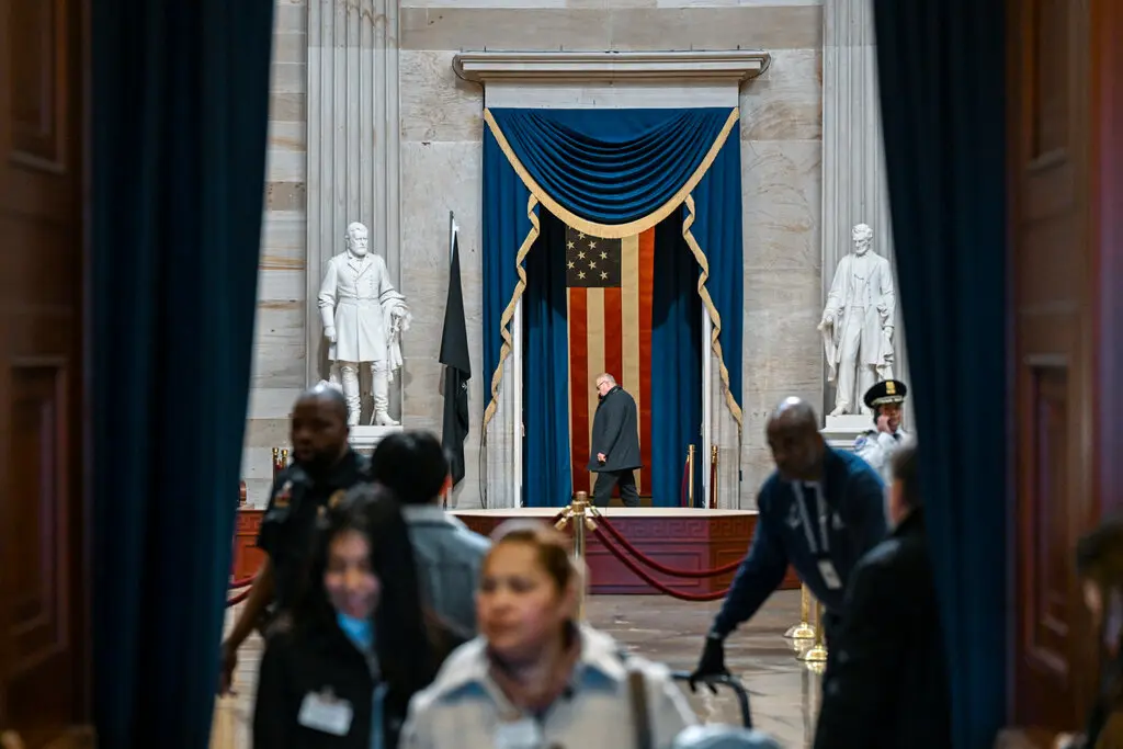 An overview of the Capitol Rotunda during the first preparations, showcasing the arrangement of ceremonial decorations and rows of folding chairs beneath the majestic dome.