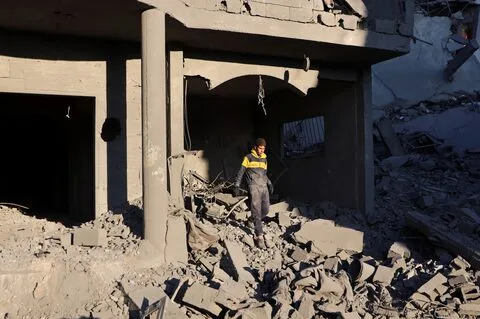  A Palestinian man surveys the aftermath of an Israeli airstrike on a house amid intensified Gaza strikes in Al Maghazi camp.