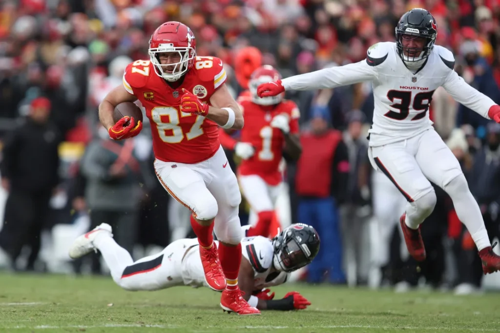 Texans defenders Henry To'oTo'o and Calen Bullock try to stop Kansas City Chiefs tight end Travis Kelce as he runs with the ball.