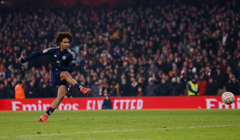 Manchester United's Joshua Zirkzee striking the winning penalty in the FA Cup shootout against Arsenal, capturing the decisive moment of victory at the Emirates Stadium.